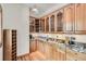 The butlers pantry features custom cabinetry with granite countertops and hardwood floors at 30671 Bearcat Trl, Conifer, CO 80433