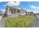 View of back of home, showing covered porch and well-maintained lawn at 7051 S White Crow Way, Aurora, CO 80016