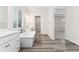 Bright bathroom with a soaking tub, dual vanity sinks, and a walk-in closet entrance in the background at 7051 S White Crow Way, Aurora, CO 80016