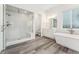 Luxurious bathroom with a glass shower enclosure, soaking tub, and modern fixtures with white cabinets at 7051 S White Crow Way, Aurora, CO 80016