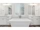 Elegant bathroom showcasing a soaking tub with modern fixtures, dual sinks, and a large window at 7051 S White Crow Way, Aurora, CO 80016