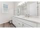 Bright bathroom with double sink vanity, white cabinets and modern finishes at 7051 S White Crow Way, Aurora, CO 80016