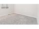 Bright bedroom featuring neutral carpeting, a window for natural light, and freshly painted white walls at 7051 S White Crow Way, Aurora, CO 80016