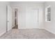 Bedroom featuring neutral carpet, with large closet and well-lit window at 7051 S White Crow Way, Aurora, CO 80016