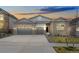 Beautiful single-Gathering home with a brick facade, manicured lawn, and a two-car garage at dusk at 7051 S White Crow Way, Aurora, CO 80016
