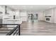Open-concept kitchen with large island, white cabinets, stainless steel appliances, open to living room with fireplace at 7051 S White Crow Way, Aurora, CO 80016