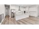 Spacious kitchen with a large center island, stainless appliances and sleek white cabinets at 7051 S White Crow Way, Aurora, CO 80016