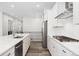 Modern kitchen featuring stainless appliances, white cabinets, and stone countertops at 7051 S White Crow Way, Aurora, CO 80016