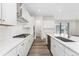 Modern kitchen featuring white cabinets, stainless steel appliances, an island with sink, and hardwood floors at 7051 S White Crow Way, Aurora, CO 80016