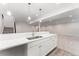 Basement kitchenette area with sink, white countertops, and stylish pendant lighting at 7051 S White Crow Way, Aurora, CO 80016