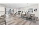 Open-concept living room featuring modern fireplace, hardwood floors, dining area, and a sliding glass door at 7051 S White Crow Way, Aurora, CO 80016