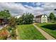 Landscaped backyard featuring a well-maintained lawn, brick pathway, and charming shed with green trim at 334 S 7Th Ave, Brighton, CO 80601