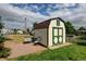 Backyard shed featuring a brown roof, green trim, and adjacent outdoor seating area at 334 S 7Th Ave, Brighton, CO 80601