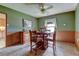 Dining room with a wooden table set, carpeted floor, and soft green walls complemented by natural light from a window at 334 S 7Th Ave, Brighton, CO 80601