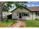 Charming home exterior featuring lush landscaping, verdant lawn, and a stone path leading to the front entryway at 334 S 7Th Ave, Brighton, CO 80601
