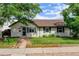 Home exterior with manicured lawn, lush landscaping, and a brick walkway leading to the front entrance at 334 S 7Th Ave, Brighton, CO 80601