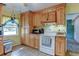 Kitchen with wooden cabinets, white oven, and tile floor for a cozy and functional space at 334 S 7Th Ave, Brighton, CO 80601