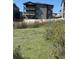 Backyard view of a modern gray home with multiple balconies overlooking a natural hillside at 6036 Riesberg Ln, Castle Rock, CO 80104
