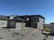 Modern two-story home featuring mixed stone and gray siding, set against a bright blue sky and minimal landscaping at 6036 Riesberg Ln, Castle Rock, CO 80104