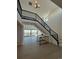 Bright, open foyer with a staircase, iron railing, hardwood floors, and views of the outdoor deck at 6036 Riesberg Ln, Castle Rock, CO 80104