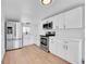 Modern kitchen featuring white cabinets, stainless steel appliances, and light wood floors at 3064 S Galapago St, Englewood, CO 80110