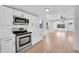 Well-lit kitchen featuring white cabinetry, stainless steel appliances, and an open layout at 3064 S Galapago St, Englewood, CO 80110