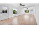 Bright living room featuring light wood floors, white walls, and multiple windows for natural light at 3064 S Galapago St, Englewood, CO 80110