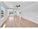 Open living room featuring light wood floors, white walls, ceiling fan, and natural light at 3064 S Galapago St, Englewood, CO 80110