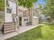 Back of house with stairs leading to the door, a patio, a small table and chair set and green grass at 1453 Vine St, Denver, CO 80206