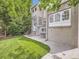 Back of house with green grass, concrete patio, steps leading to the back door and mature trees at 1453 Vine St, Denver, CO 80206