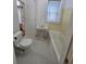 Bright bathroom features a classic pedestal sink, bathtub, and white hexagon tile flooring at 1453 Vine St, Denver, CO 80206