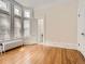 Sunlit bedroom features a bay window, hardwood floors, white trim and an open door to another room at 1453 Vine St, Denver, CO 80206