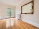 Bright, spacious bedroom featuring hardwood floors, a large mirror, and access to an outdoor balcony at 1453 Vine St, Denver, CO 80206