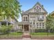 Elegant stone home with a gated front yard, a covered entryway, and detailed architectural features at 1453 Vine St, Denver, CO 80206