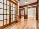 Elegant hallway with hardwood floors, wood trim, glass-paneled doors, and spacious layout at 1453 Vine St, Denver, CO 80206