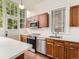 Kitchen features wood cabinets, stainless steel appliances, white countertops, and large windows with natural light at 1453 Vine St, Denver, CO 80206
