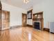 Living room features hardwood floors, fireplace with decorative mantle, wood trim, and natural light at 1453 Vine St, Denver, CO 80206