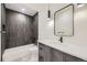Modern bathroom with a sleek vanity, stylish mirror, and tub with beautiful gray vertical tiling at 2378 S Bannock St, Denver, CO 80223