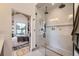 Modern glass-enclosed shower with dual shower heads, view of bedroom and backyard through picture window at 2378 S Bannock St, Denver, CO 80223