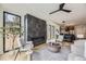 Living room featuring a stylish fireplace, large windows, hardwood floors, and contemporary furnishings at 2378 S Bannock St, Denver, CO 80223
