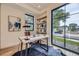 Cozy home office with a wooden desk, a black rug, and large windows with natural light at 2378 S Bannock St, Denver, CO 80223