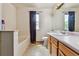 Bathroom featuring a tub, tile floors, a large mirror and a vanity with natural lighting from a window at 20651 E 42Nd Ave, Denver, CO 80249