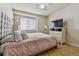 Bedroom with a bed, nightstand with flowers, mirror and chest of drawers with TV at 20651 E 42Nd Ave, Denver, CO 80249