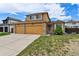 Two-story home with a three-car garage, stone accents and manicured lawn under a blue sky at 20651 E 42Nd Ave, Denver, CO 80249