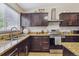 Kitchen featuring dark wood cabinets, granite countertops, and stainless steel appliances at 20651 E 42Nd Ave, Denver, CO 80249
