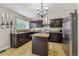 Modern kitchen featuring dark wood cabinets, stainless steel appliances and a granite island at 20651 E 42Nd Ave, Denver, CO 80249