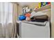 A functional laundry room with white washer and dryer, storage shelves, and natural light at 20651 E 42Nd Ave, Denver, CO 80249