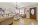 Bright living room featuring neutral tones, a chandelier, and a decorative entry door at 20651 E 42Nd Ave, Denver, CO 80249
