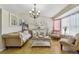 Elegant living room featuring tile floors, neutral furniture and a chandelier at 20651 E 42Nd Ave, Denver, CO 80249