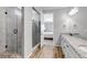 Modern bathroom featuring walk-in shower, granite countertop, and wood-look flooring at 9055 Swan River St, Littleton, CO 80125